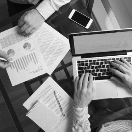 Business people using laptop and looking at charts